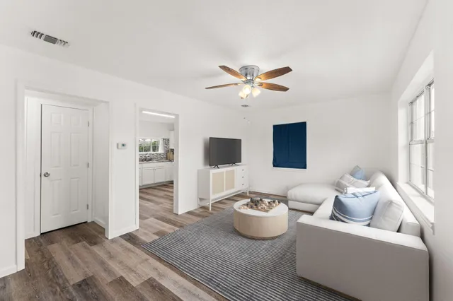 a living room with furniture and a wooden floor