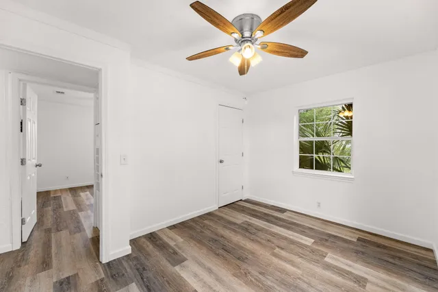 an empty room with a window and a ceiling fan