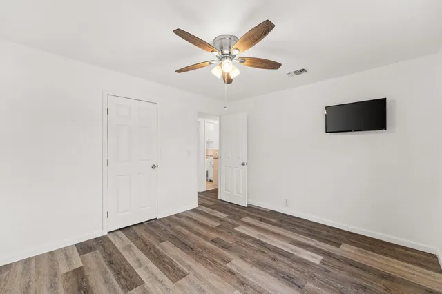 a view of a livingroom with a ceiling fan and wooden floor