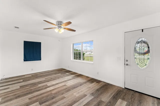 a view of a big room with wooden floor and a window