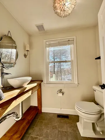a bathroom with a toilet a sink and mirror