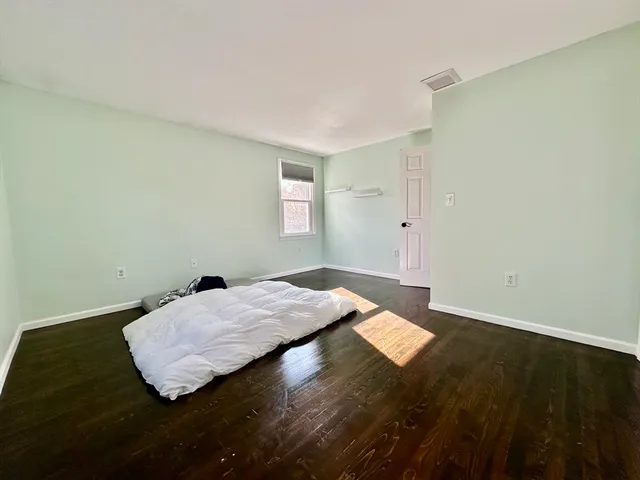 a bed sitting in a bedroom next to a window