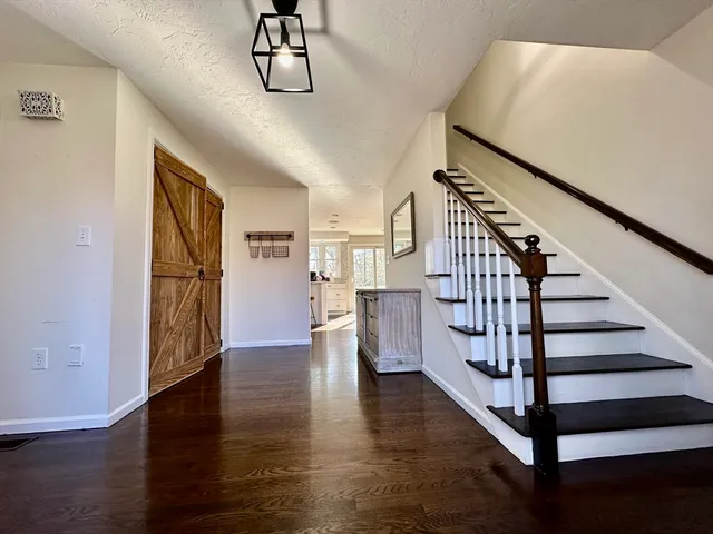 a view of entryway and hall with wooden floor