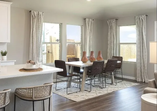 a living room with furniture a wooden floor and a large window
