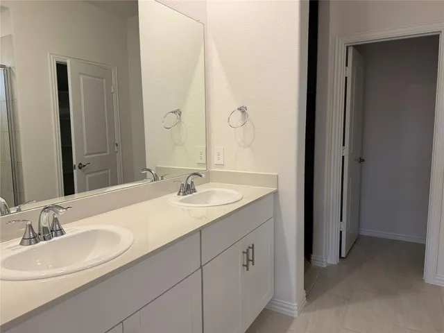 a bathroom with a double vanity sink mirror and shower
