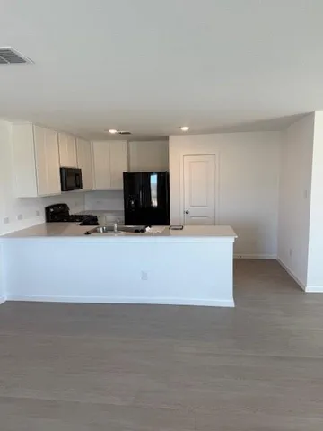 a kitchen with granite countertop white cabinets and stainless steel appliances