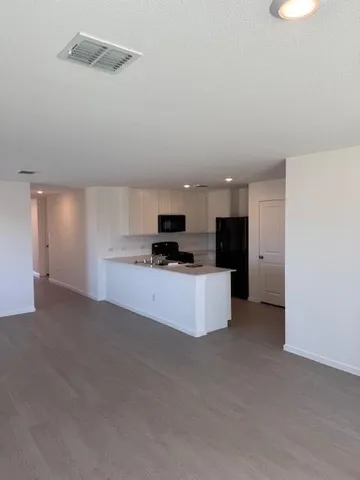 a view of kitchen with kitchen island stainless steel appliances sink and cabinets