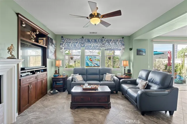 a living room with furniture a fireplace and a chandelier
