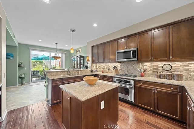 a kitchen with granite countertop kitchen island wooden cabinets and stainless steel appliances
