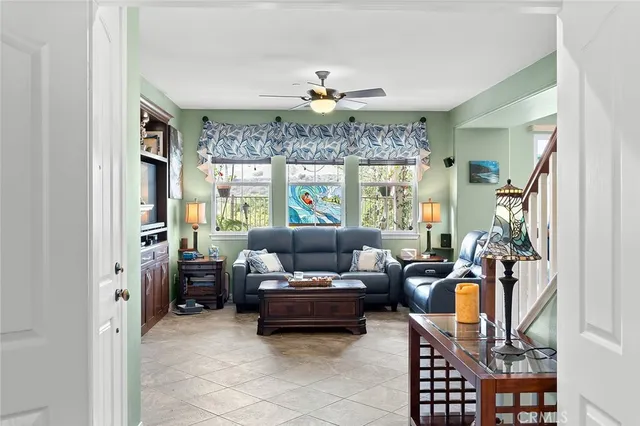 a view of a hallway to a livingroom with wooden floor and furniture