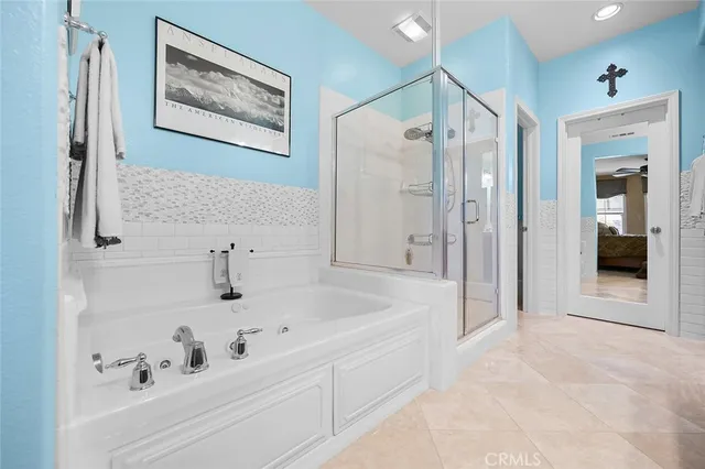 a spacious en suite bathroom with a double vanity sink a mirror and a shower