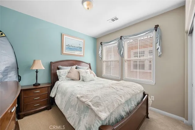 a bedroom with a large bed and a flat tv screen on dresser