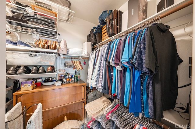 a view of walk in closet with clothes and shoes