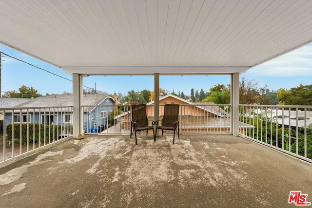 a view of a house with wooden deck and furniture