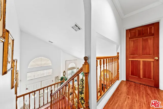 a view of a hallway with wooden floor and staircase