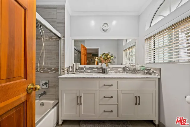 a bathroom with a granite countertop sink mirror and a bathtub