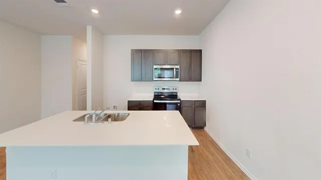 a kitchen with a sink a stove and cabinets