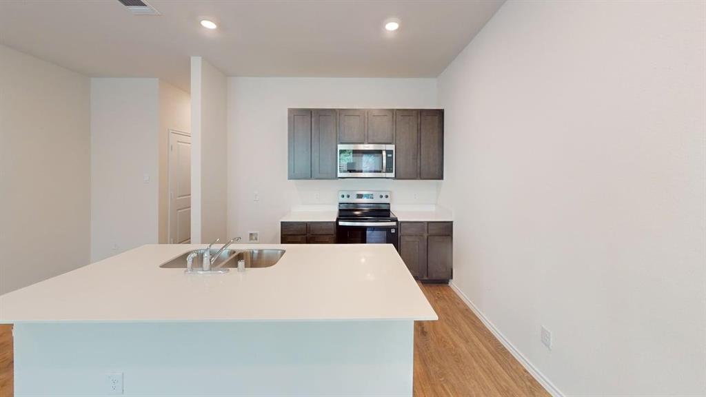 311 Clematis Street Princeton, TX 75407 - Photo 4 of 20 a kitchen with a sink a stove and cabinets