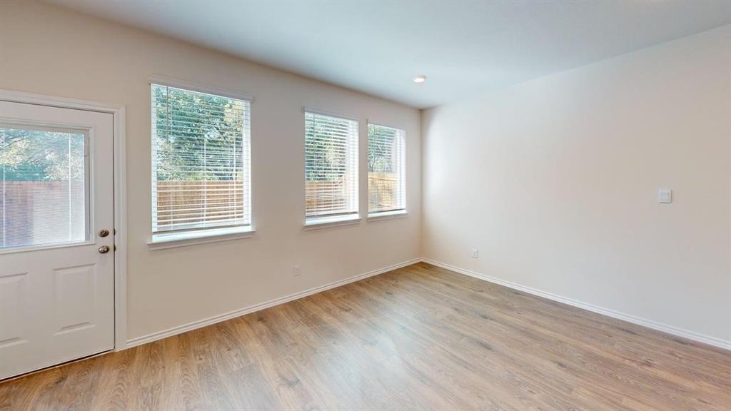 311 Clematis Street Princeton, TX 75407 - Photo 8 of 20 an empty room with wooden floor and windows
