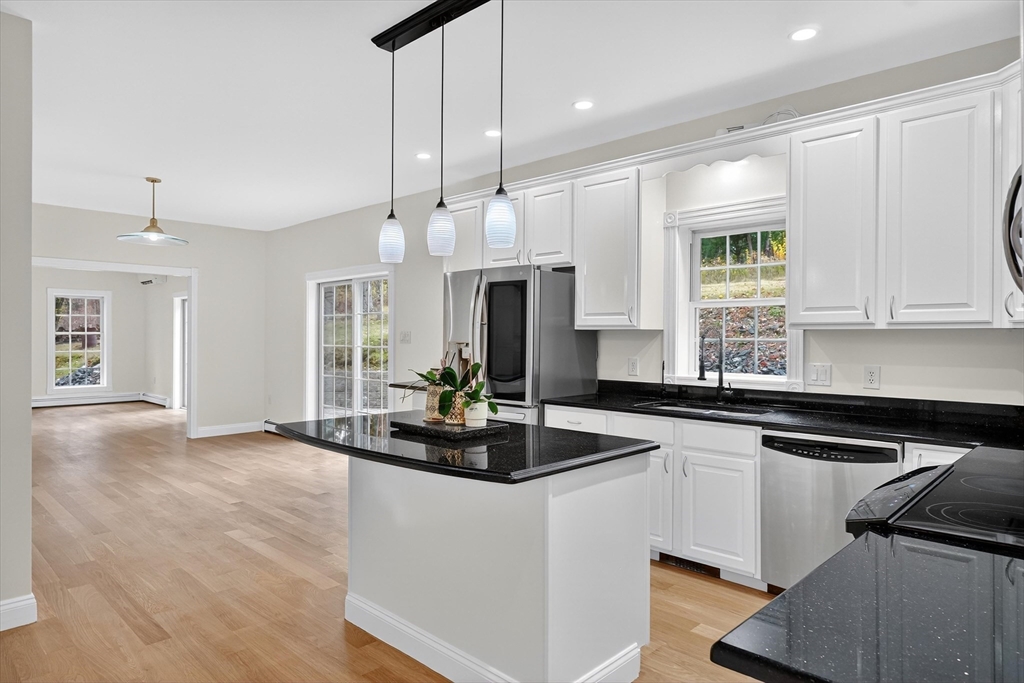 14 Pine Hill Road Framingham, MA 01701 - Photo 14 of 42 a kitchen with kitchen island granite countertop a sink cabinets and wooden floor