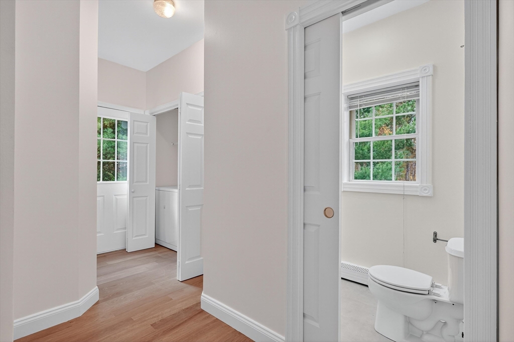 14 Pine Hill Road Framingham, MA 01701 - Photo 31 of 42 a bathroom with a toilet a sink a window and wooden floor