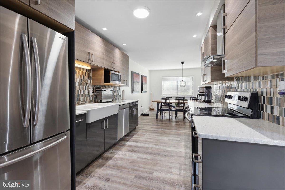 a kitchen with stainless steel appliances lots of counter top space refrigerator and cabinets