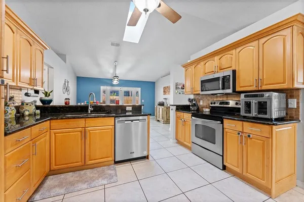 a kitchen with stainless steel appliances granite countertop a refrigerator and a sink