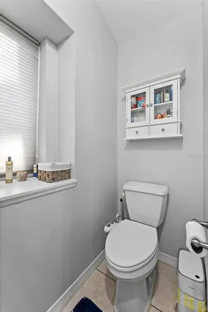 a bathroom with a granite countertop sink a toilet and a mirror