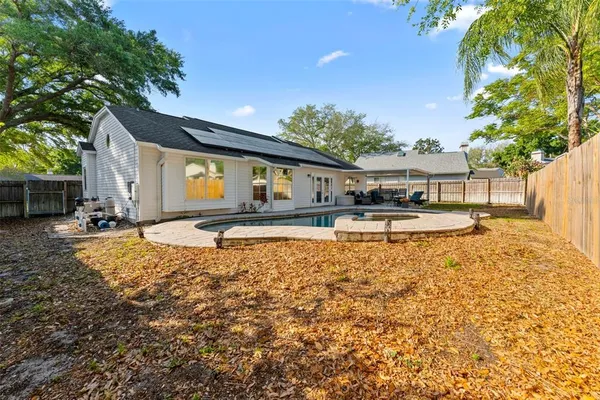 an aerial view of residential houses with outdoor space and trees