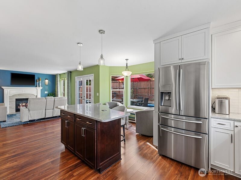 1504 Fuller Street Wenatchee, WA 98801 - Photo 13 of 38 a kitchen with stainless steel appliances granite countertop a refrigerator a sink dishwasher and white cabinets with wooden floor