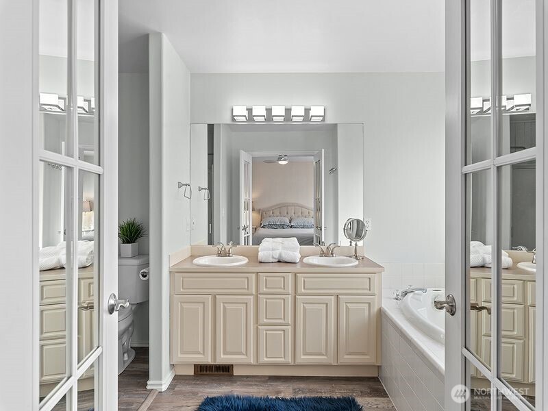 1504 Fuller Street Wenatchee, WA 98801 - Photo 32 of 38 a bathroom with a double vanity sink a mirror and a bathtub