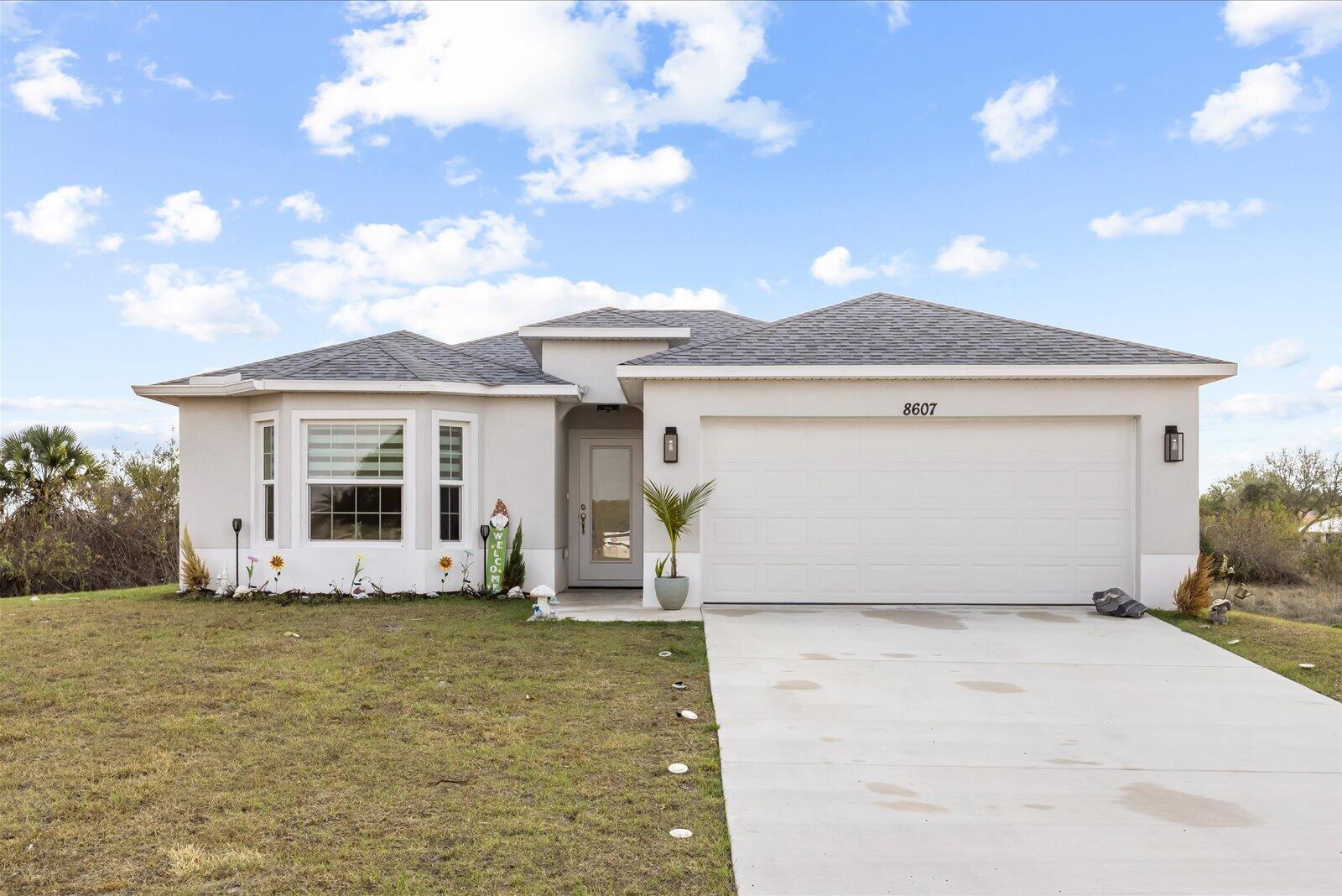 8607 Southwest 7th Lane Okeechobee, FL 34974 - Photo 1 of 44 a front view of a house with a yard and potted plants