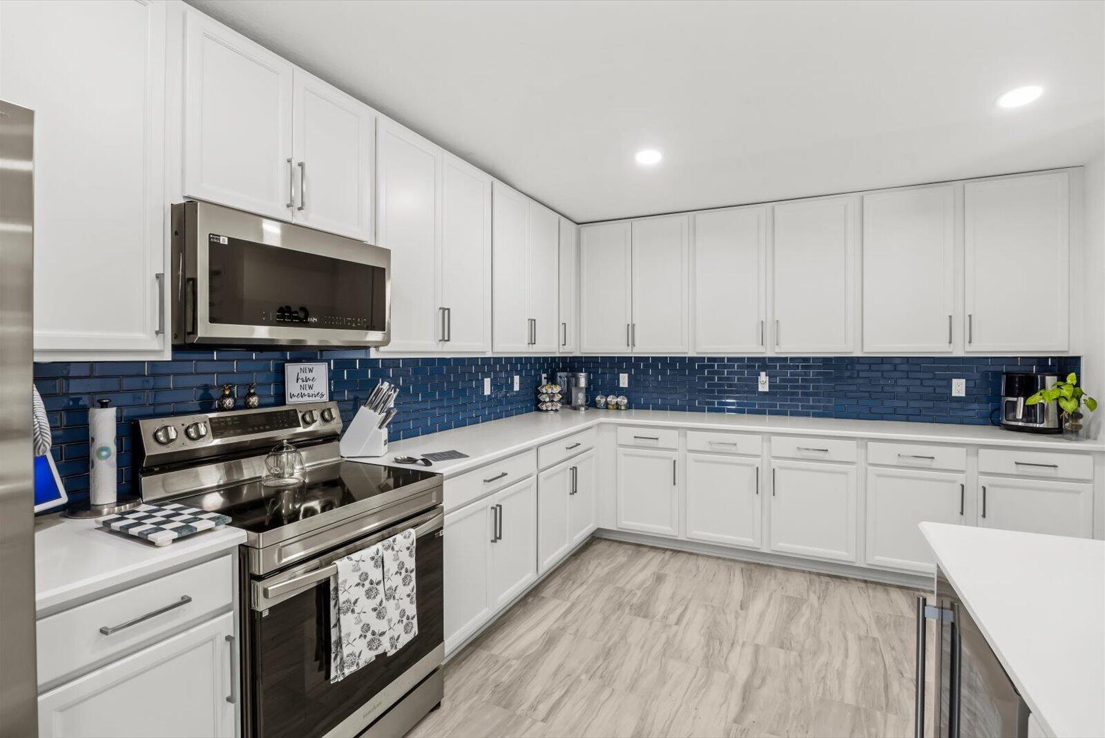 8607 Southwest 7th Lane Okeechobee, FL 34974 - Photo 14 of 44 a kitchen with stainless steel appliances granite countertop a stove a sink and a microwave