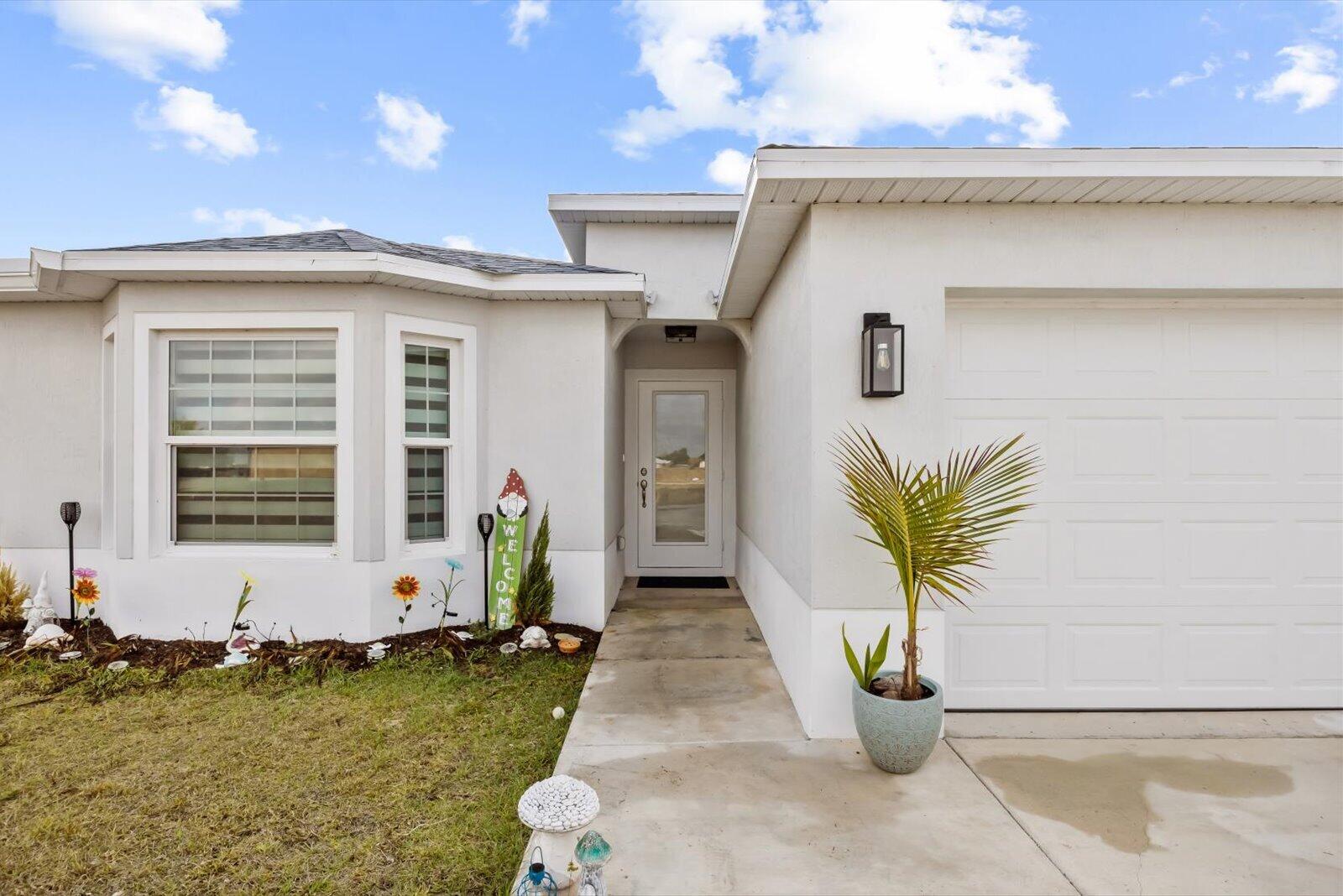8607 Southwest 7th Lane Okeechobee, FL 34974 - Photo 3 of 44 a front view of a house with garden