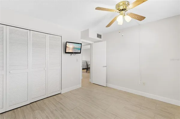an empty room with a ceiling fan and a window