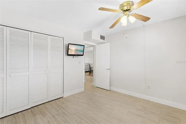 an empty room with a ceiling fan and a window