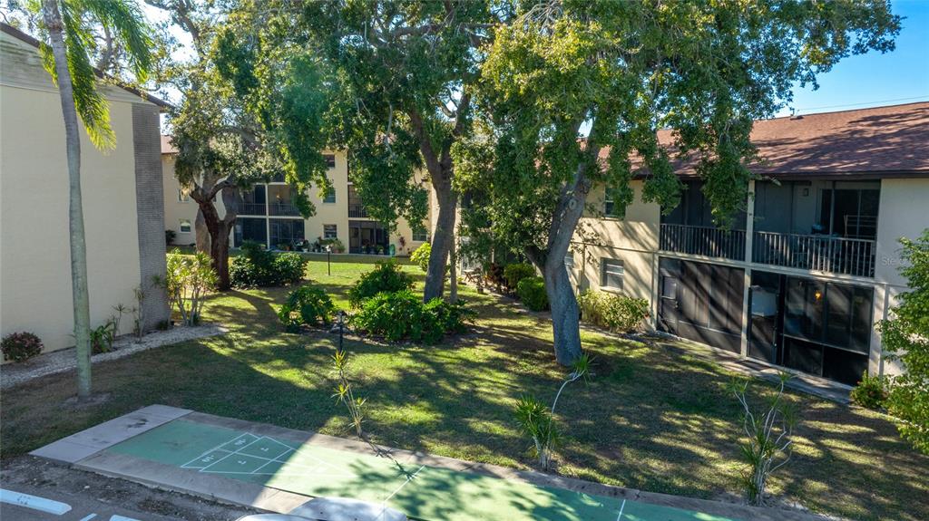 2300 Stickney Point Road, Unit 102 Sarasota, FL 34231 - Photo 21 of 32 a view of a chair and table in backyard