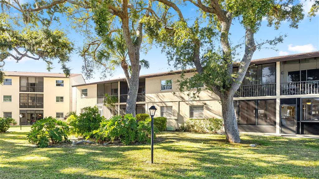 2300 Stickney Point Road, Unit 102 Sarasota, FL 34231 - Photo 23 of 32 a house with a tree in front of it