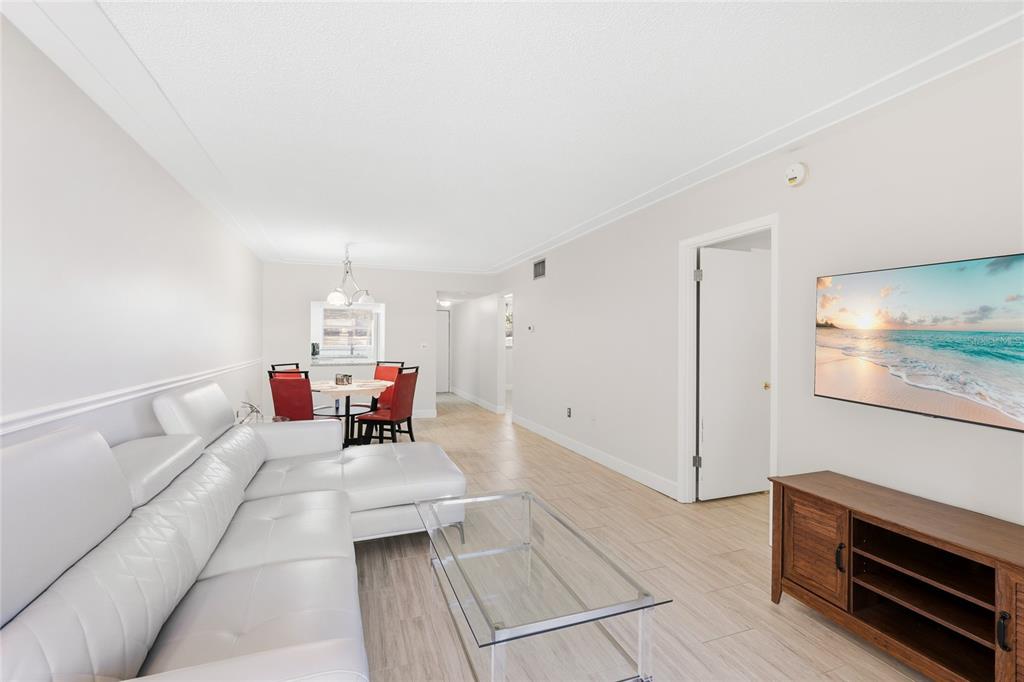 2300 Stickney Point Road, Unit 102 Sarasota, FL 34231 - Photo 5 of 32 a living room with furniture and a chandelier