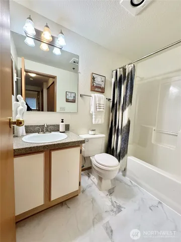a bathroom with a granite countertop toilet sink and a mirror