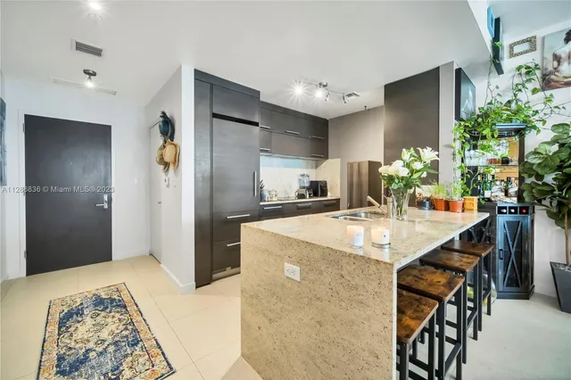 a kitchen with stainless steel appliances kitchen island granite countertop a refrigerator and a sink