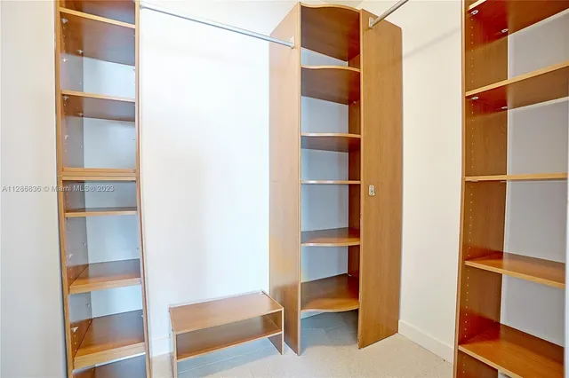 a view of walk in closet with empty racks