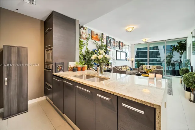 a kitchen with granite countertop a sink and refrigerator