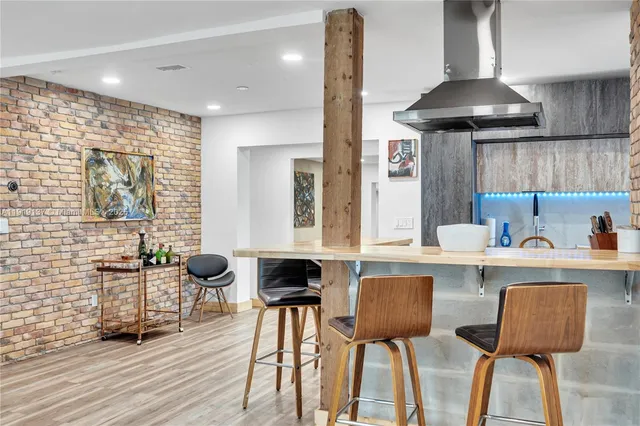 a kitchen with a dining table chairs and a wooden floor