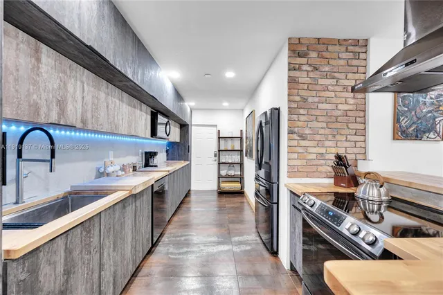 a kitchen with stainless steel appliances a sink dishwasher stove refrigerator and microwave