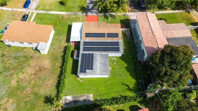 an aerial view of a house with a yard basket ball court and outdoor seating
