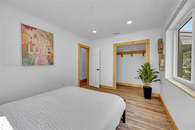 a spacious bedroom with a bed and a dresser