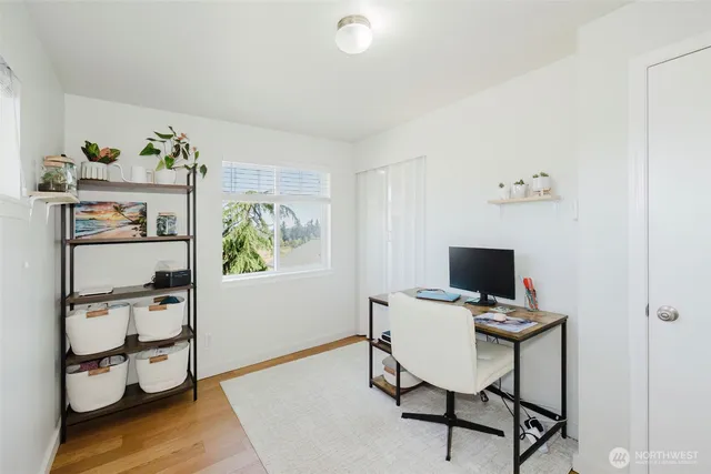 a view of a workspace with furniture and wooden floor