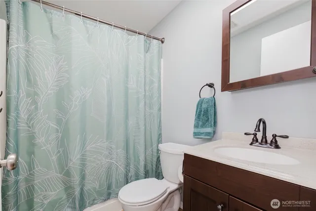 a bathroom with a sink a toilet and shower curtain