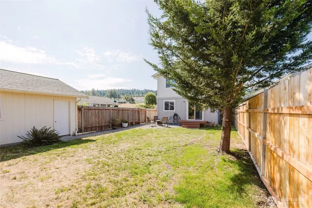 a view of backyard with swimming pool and seating space